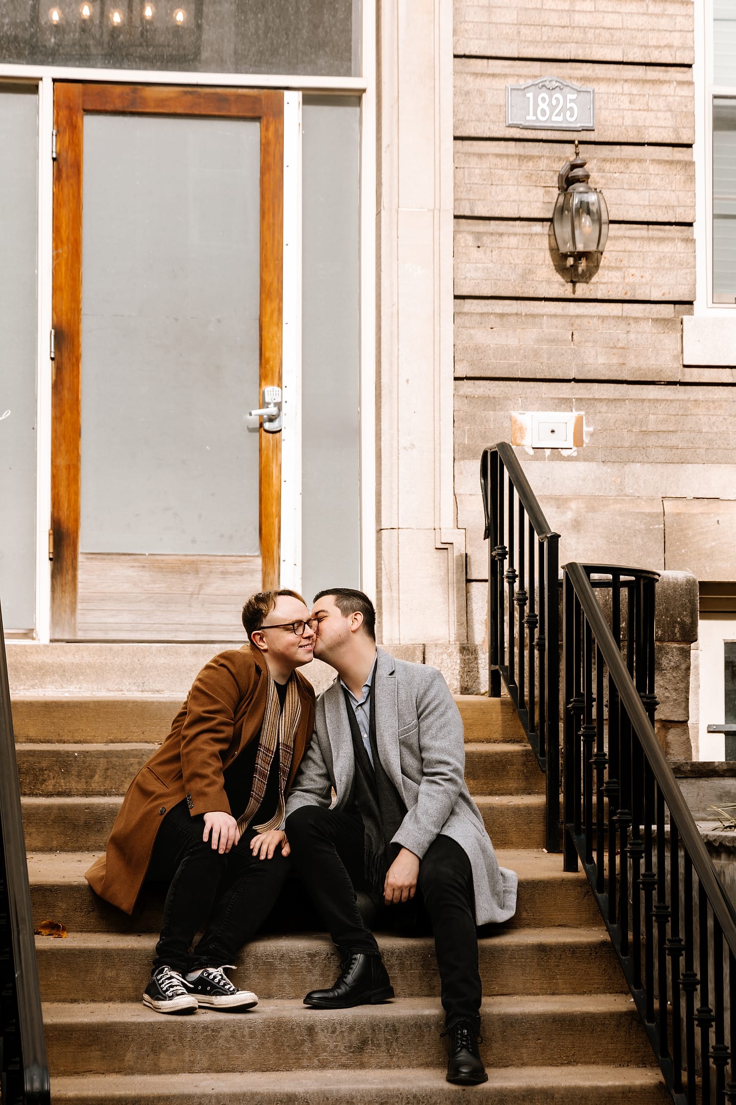 Eric and JJ kissing on the steps of an Adams Morgan row house during their Washington, DC engagement session