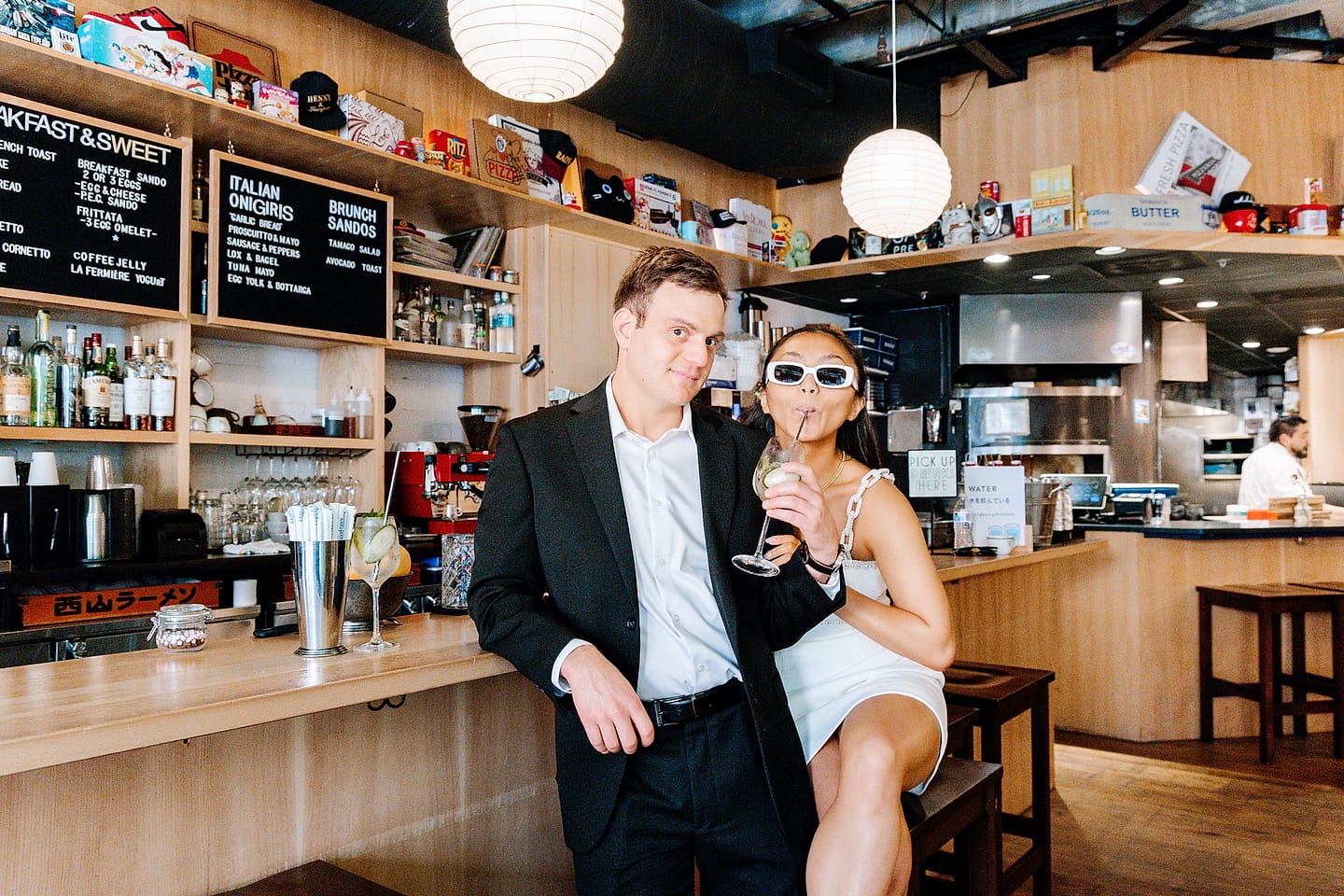 Aaron holding Jasmine close at the Tonari bar as she sips a drink during their Chinatown DC engagement session