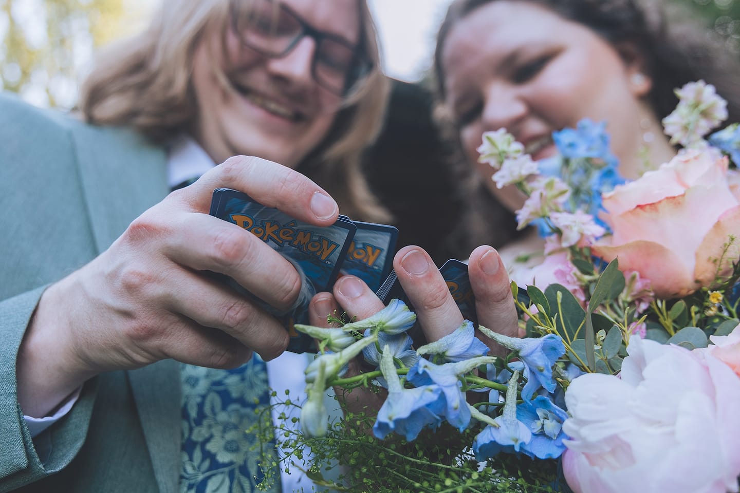 Newlyweds share a Pokemon keepsake over a peach and blue bouquet at their DMV wedding