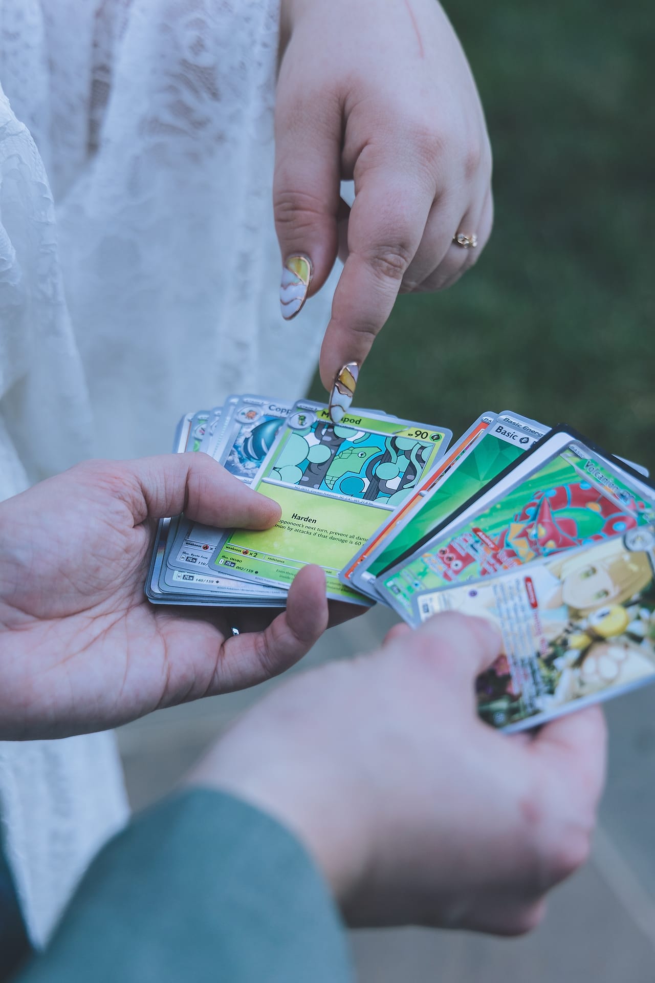Newlyweds share Pokemon trading cards in a playful detail shot at their DMV garden wedding