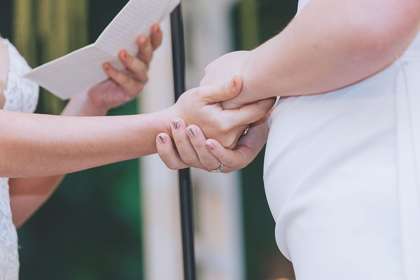 Two brides sharing a kiss at their outdoor ceremony