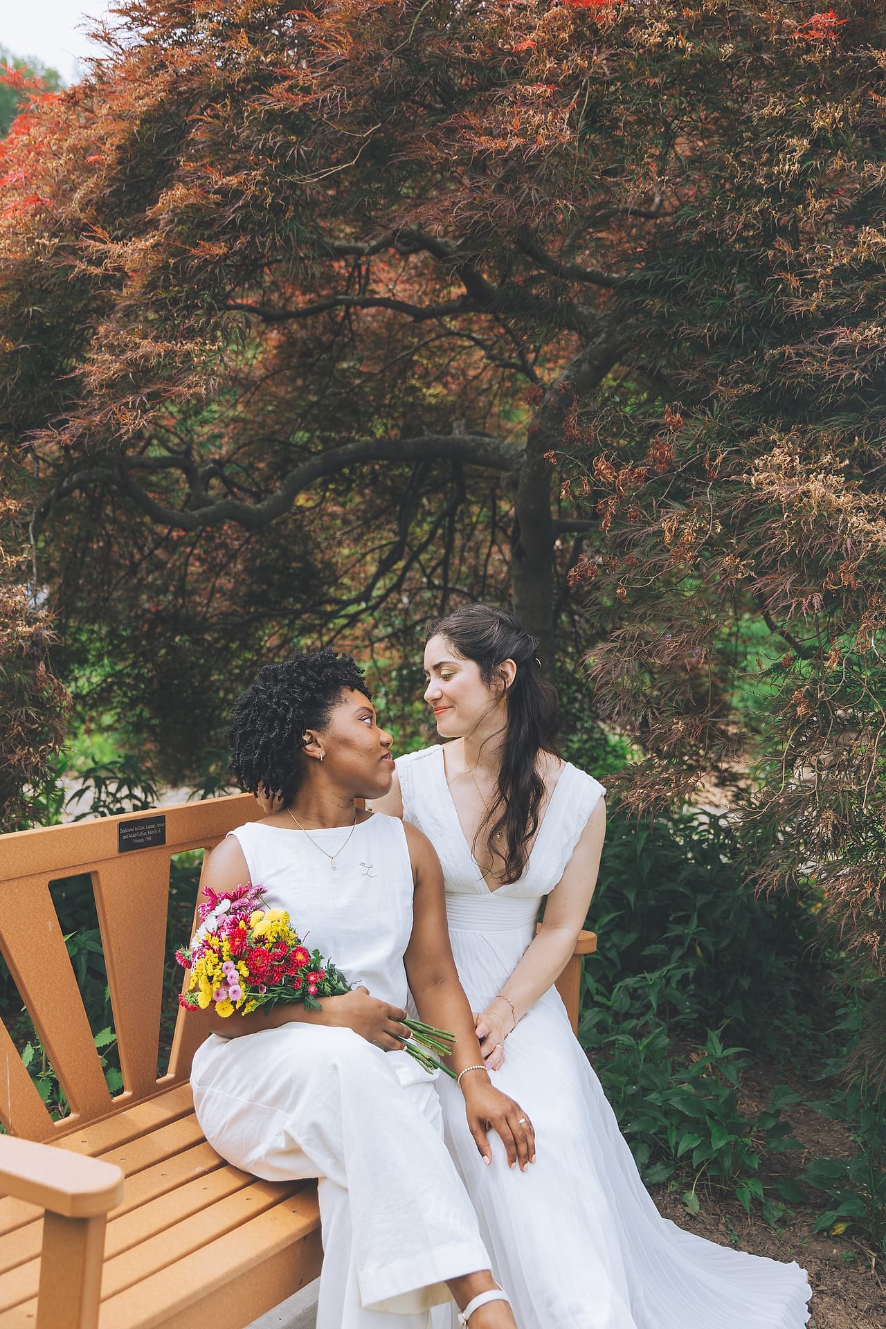 A newlywed couple celebrating together in a sunlit woodland